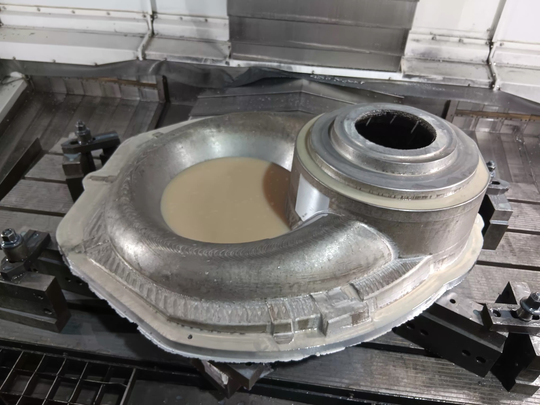 Large machined metal pattern secured to a CNC machine bed