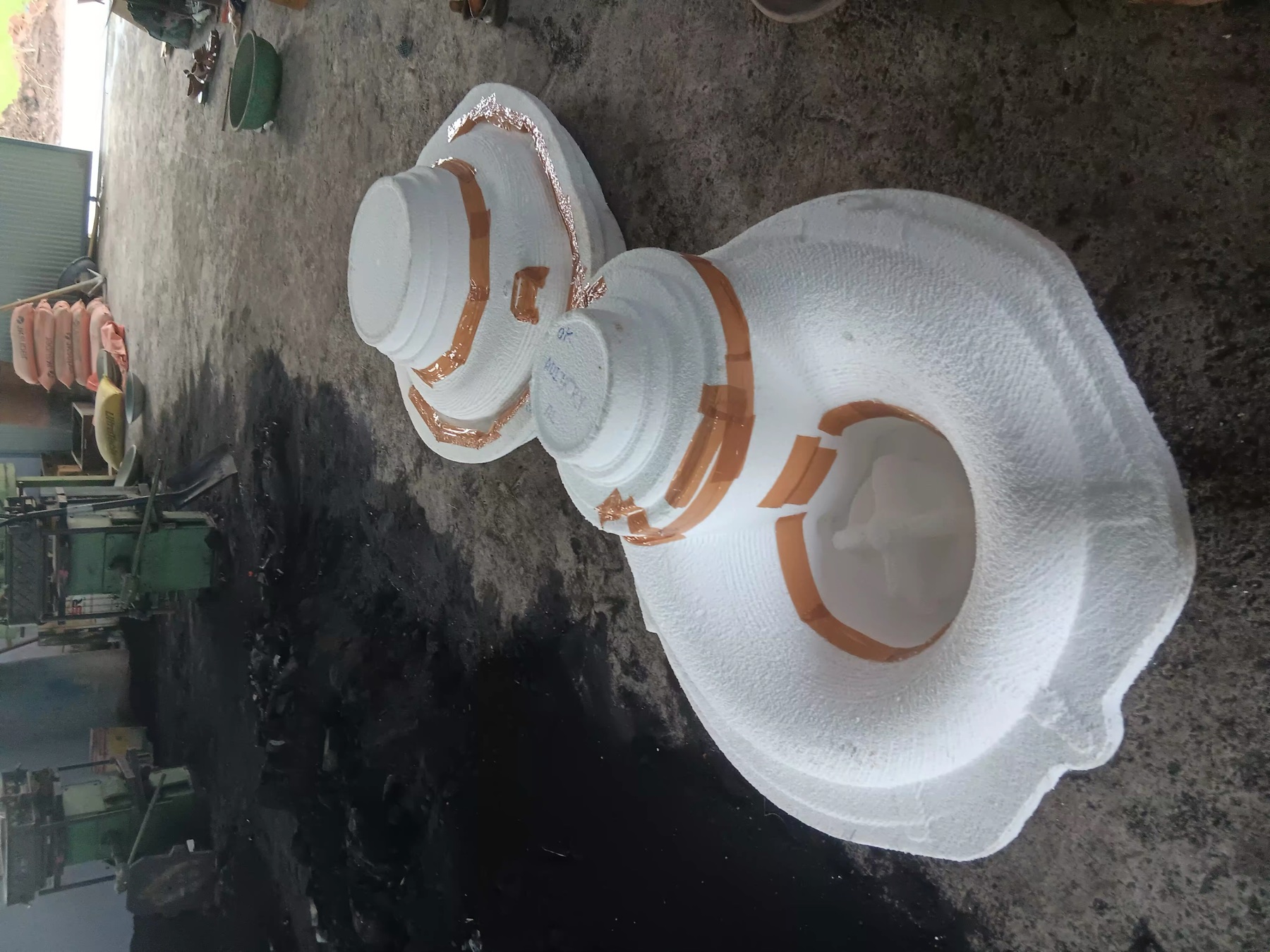 Two white industrial patterns prepared on a foundry workshop floor