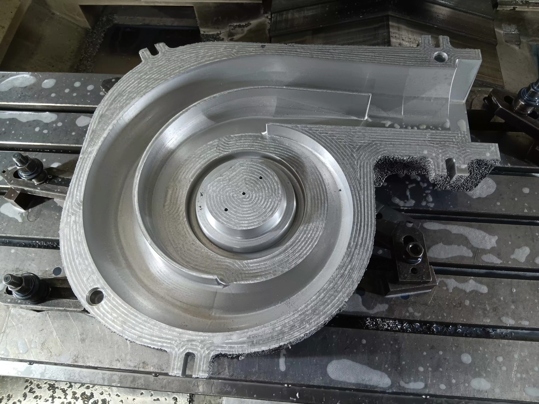 Close view of a machined aluminium pattern showing complex curves and tool paths
